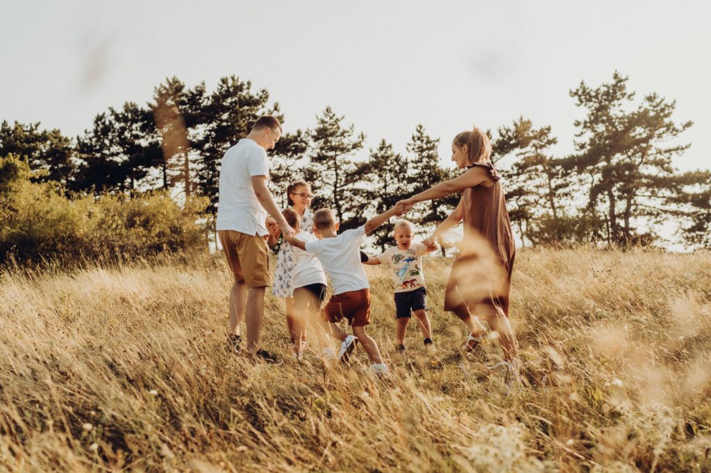 Nagy család játékos kültéri családi fotózáson a Pilisben, természetes fényben készült elkapott pillanat