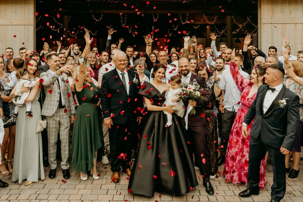 Esküvői csoportkép konfettivel az Event’s Hill panorámás udvarházán, násznép ünnepel a Hármashatár-hegy tetején Budapest felett